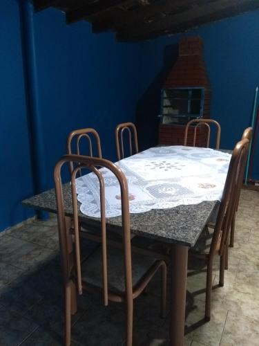 a dining room table with four chairs around it at House Blue Confort in Anápolis