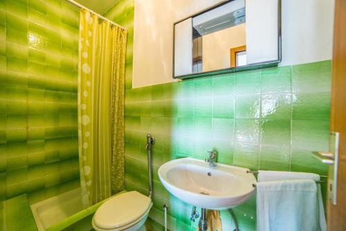 a bathroom with a sink and a toilet and a mirror at Apartments Antić 4255 in Selce