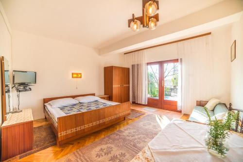 a bedroom with a bed and a television in it at Apartments Antić 4255 in Selce