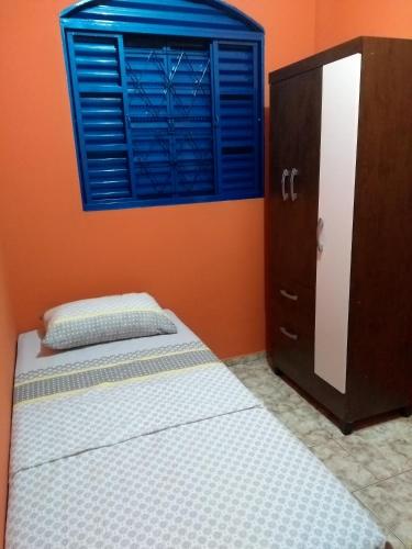 a bedroom with a bed and a blue window at House Blue Confort in Anápolis