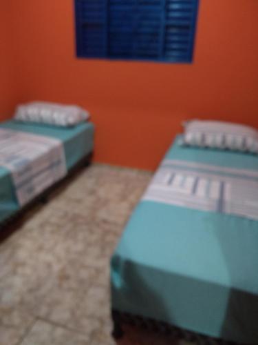 two beds sitting next to each other in a room at House Blue Confort in Anápolis