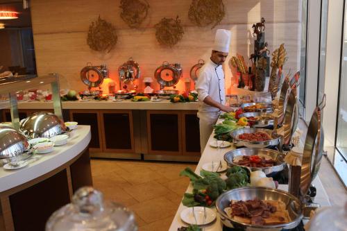 a table filled with lots of different types of food at Elite Crystal Hotel in Manama