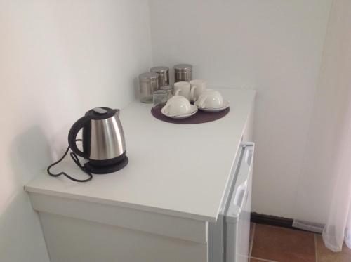 a table with a tea kettle and cups on it at Sikelela Guest House in Cape Town