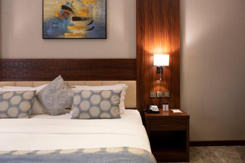 a hotel room with a bed and a table with a lamp at mawasim al hay at hotel in Jeddah
