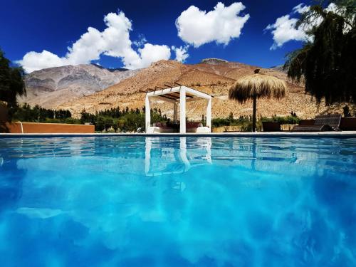 a pool with a gazebo and blue water at Reset Elqui in Alcoguaz