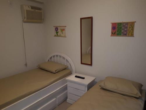a small bedroom with two beds and a mirror at CALDAS NOVAS Aconchego e Diversão in Caldas Novas