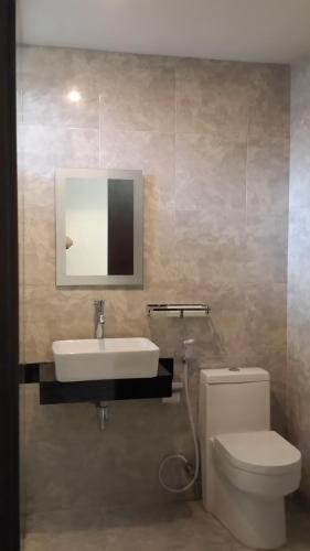 a bathroom with a sink and a toilet and a mirror at White Rock Lodge in Nusa Dua
