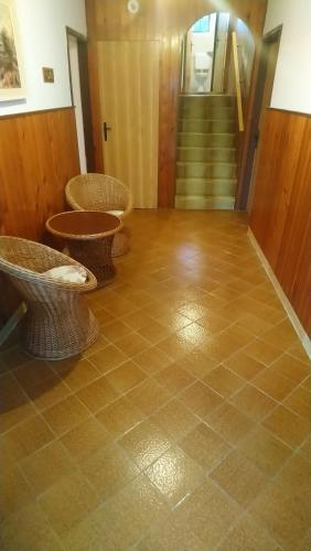 a room with two chairs and a staircase with a tiled floor at Apartment Vidas in Kampor