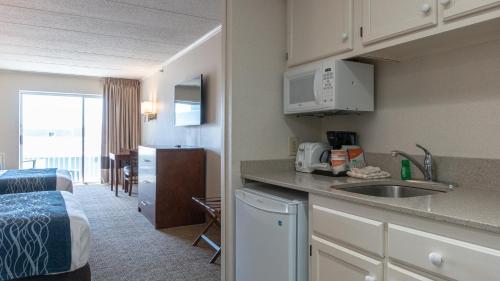 a kitchen with a sink and a room with a bed at Comfort Inn Ocean City Boardwalk in Ocean City