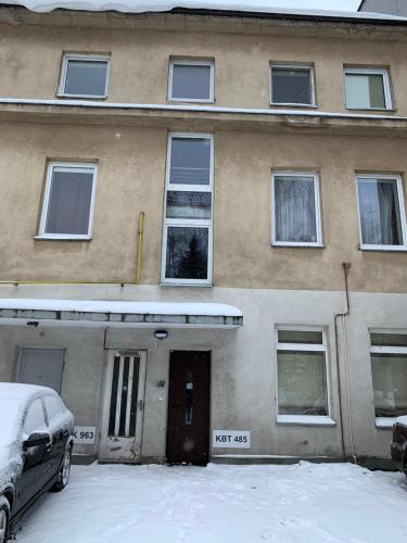 a building with snow in front of it at Comfortable Stay in Siauliai in Šiauliai