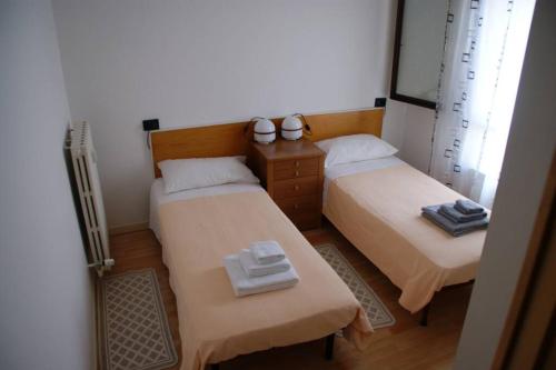 twee bedden in een kleine kamer met handdoeken erop bij Appartamento Casa Paola in Vigonza