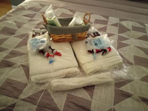 eine Gruppe Handtücher und ein Korb auf dem Bett in der Unterkunft Albergue Camiño Real in Sigüeiro