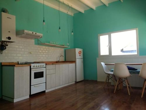 a kitchen with green walls and a table with chairs at Cabaña Buccia in Mar del Plata