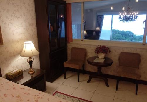 a bedroom with a table and a chair and a window at Villa High Wharf in Wanli District
