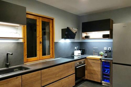 une cuisine avec un évier et un réfrigérateur dans l'établissement *** Le Refuge *** Logement standing Megève, à Demi-Quartier