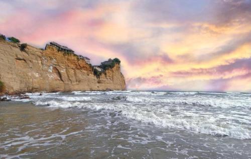 a view of the ocean from the beach with cliffs at Rincón d'Olón Boutique Hotel in Olón