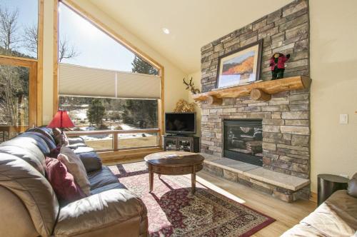 a living room with a couch and a fireplace at Tranquility On The River Four -- EV #6041 townhouse in Estes Park