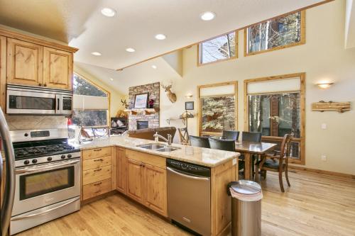 een keuken met een tafel en een eetkamer bij Tranquility On The River Four -- EV #6041 townhouse in Estes Park