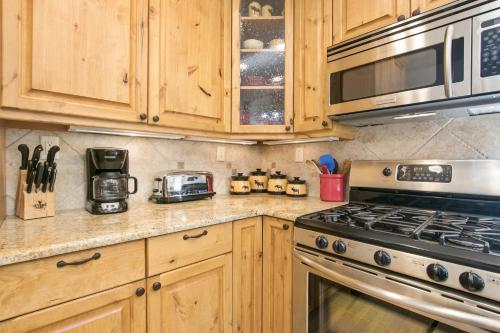 a kitchen with wooden cabinets and a stove top oven at Tranquility On The River Four -- EV #6041 townhouse in Estes Park