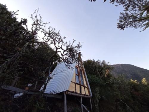 a tree house with a roof on a hill at Cabañas el Paraiso Sesquile in Sesquilé