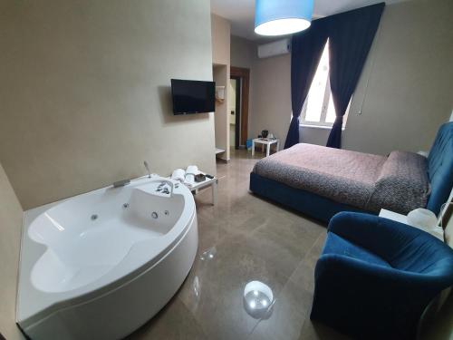 a bathroom with a tub and a bedroom with a bed at Beverello Suite in Naples
