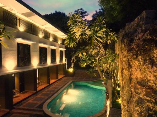 a swimming pool in front of a house at night at White Rock Lodge in Nusa Dua