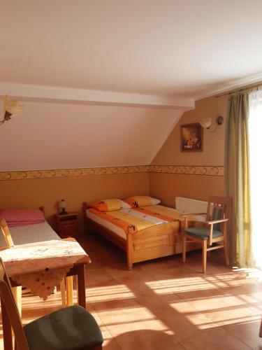 a bedroom with two beds and a table and chairs at Willa Feniks in Łeba