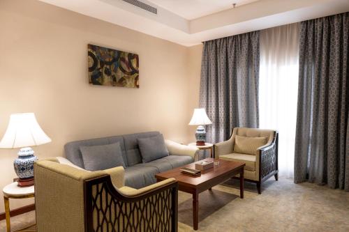 a living room with a couch and chairs and a table at mawasim al hay at hotel in Jeddah