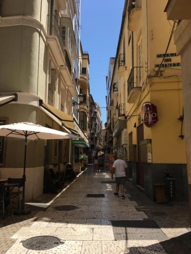 a man walking down a street in an alley at Picasso City Center 1A in Málaga