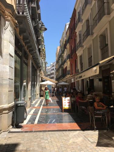 a woman walking down a street in a city at Picasso City Center 1A in Málaga