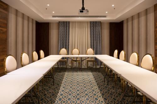 a long conference room with a long table and chairs at mawasim al hay at hotel in Jeddah