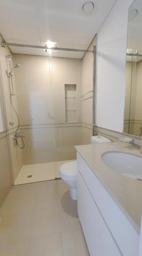 a bathroom with a toilet and a sink and a shower at Spacious 2 Bedroom Apartment DXB in Dubai