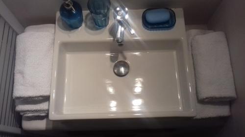 a white sink in a bathroom with towels at Katoikia Spathi in Spathi 