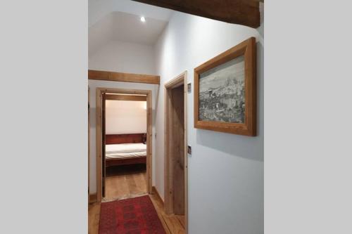 a hallway with a bed and a painting on a wall at Traditional coach house in rural private estate. in Yeovil