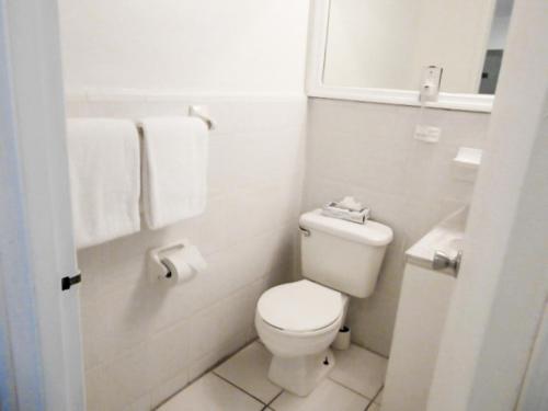 a white bathroom with a toilet and a sink at Miami BeachFront with Pool WIFI & Cheap parking in Miami Beach