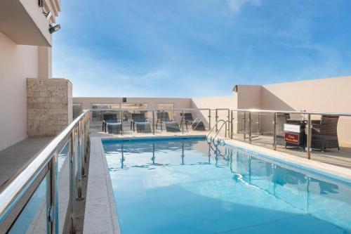 a large swimming pool with chairs on a building at mawasim al hay at hotel in Jeddah
