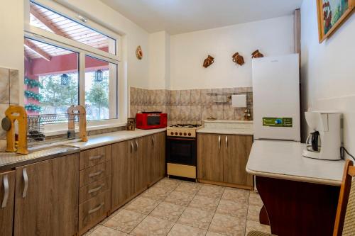 a kitchen with wooden cabinets and a white refrigerator at Pensiunea Bucovina in Gura Humorului