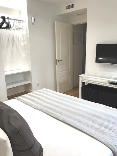 a bedroom with a bed and a flat screen tv at Picasso City Center 1A in Málaga