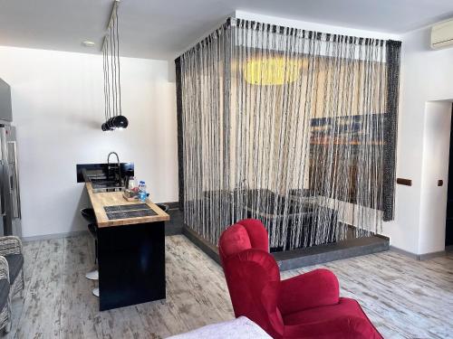 a living room with a red chair and a desk at Apartament z tarasem in Wisełka