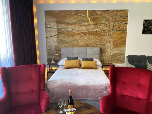 a bedroom with a bed and two red chairs at Apartament z tarasem in Wisełka
