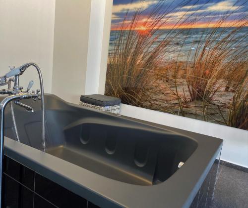 a bathroom sink with a view of the beach at Apartament z tarasem in Wisełka