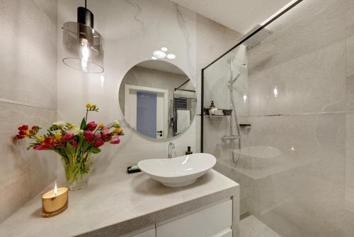 a white bathroom with a sink and a mirror at Seven Heaven in Katowice