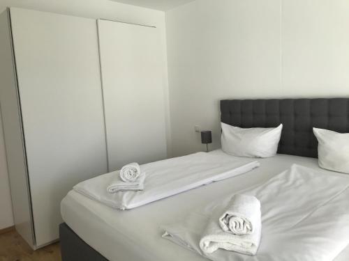 a white bed with towels and pillows on it at Apartment Berg und See in Schliersee