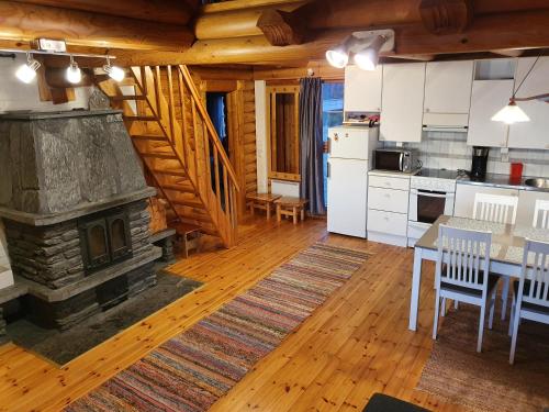 a kitchen and dining room with a stone fireplace at Koivuranta in Pihtipudas