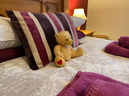 a teddy bear sitting on top of a bed at Station House, Dartmoor and Coast located, Village centre Hotel in South Brent