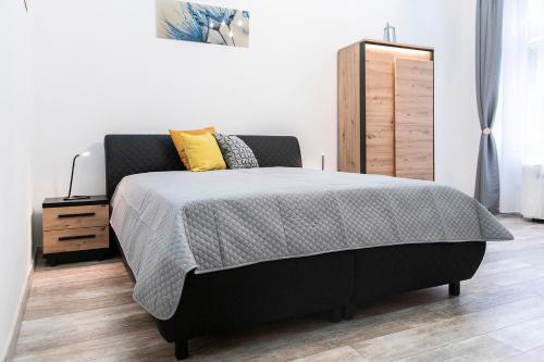 1 dormitorio con cama negra y almohadas amarillas en Astoria Tiny Apartment en Budapest