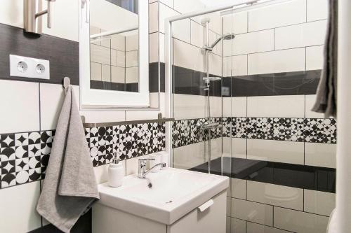 y baño blanco con lavabo y ducha. en Astoria Tiny Apartment en Budapest