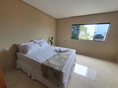 um quarto com uma cama grande e uma janela em CASA VISTA MAR SÃO JOSÉ ANTUNES MARAGOGI em São José da Coroa Grande