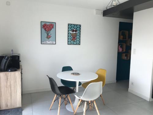 une salle à manger avec une table et des chaises blanches dans l'établissement Dans la Pouncho d’Agast, à Millau