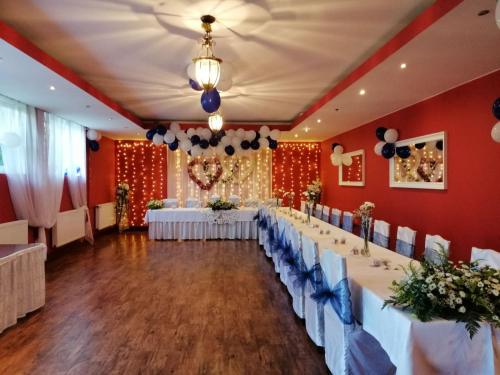 a banquet hall with white tables and blue chairs at Zielone Wzgórze in Wałbrzych